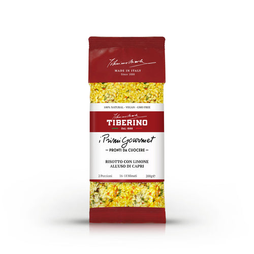 Confezione rossa di Risotto con Limone all'uso di Capri Tiberino 1888, 200g, con riso giallo e spezie visibili.