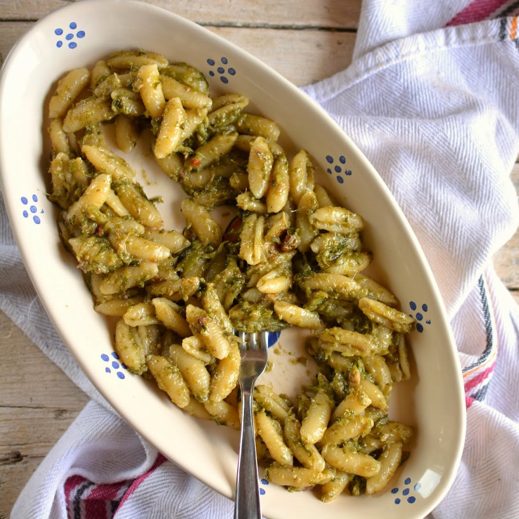 piatto di ceramica ovale con cavatelli con verdure su strofinaccio bianco su tavola di legno grezzo